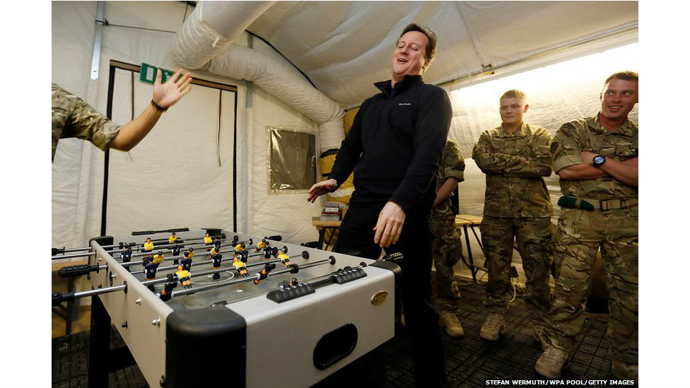 ब्रितानी प्रधानमंत्री डेविड केमरन अफगानिस्तान की हेलमंद घाटी के एक सैन्य शिविर में सैनिकों के साथ हँसी-मजाक करते हुए.