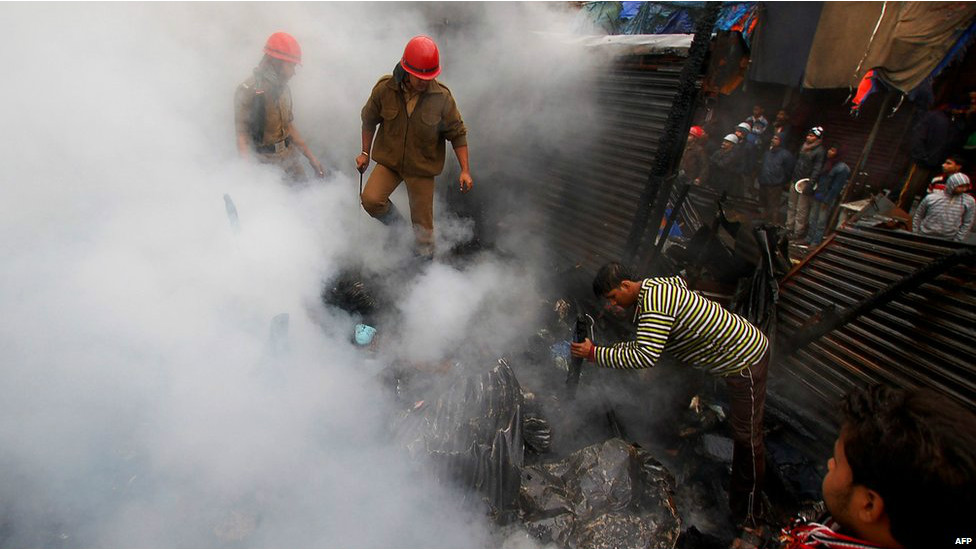 भारतीय राज्य त्रिपुरा में एक मार्केट में आग लगने के बाद आग पर नियंत्रण पाने की कोशिश करते दमकलकर्मी. इस आगजनी में करीब बीस दुकानें जलकर खाक हो गईं.